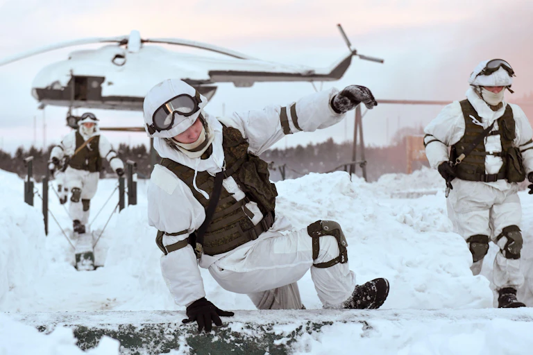 Russian soldiers wearing arctic uniforms take part in exercises after leaving a helicopter