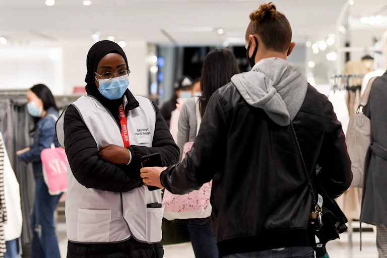 Retail staff check QR code check-ins in a shop in Sydney's Pitt Street Mall , Monday, October 11 2021.