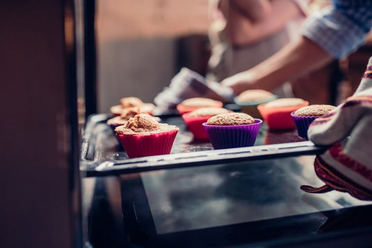 baking cupcakes pulled from over by adult and child