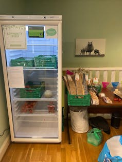 A glass door refrigerator with a sign reading Community Fridge.