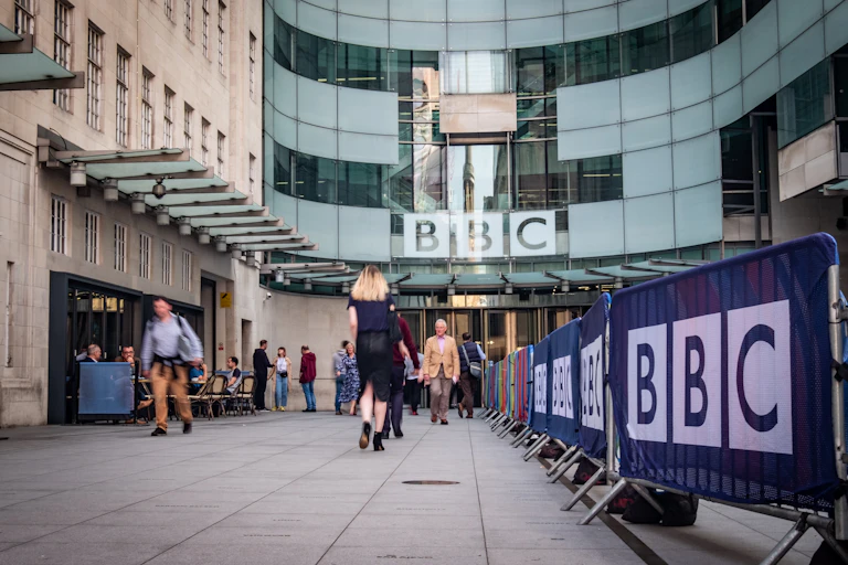 People walking in and out of the entrance to the BBC headquarters at Broadcasting House in central London