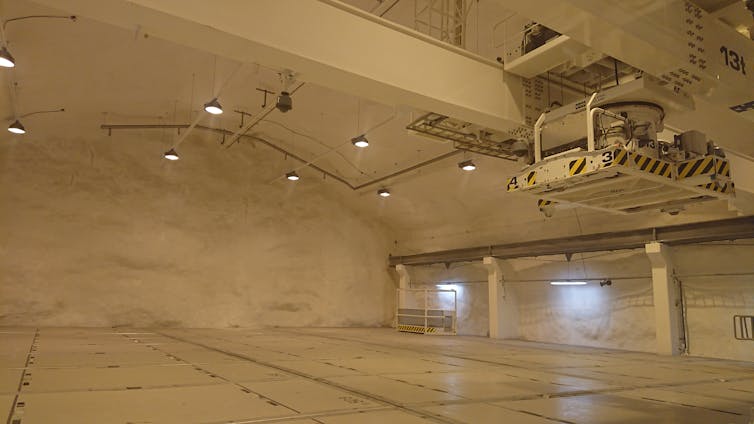 A large underground empty room, brightly lit with cream-coloured walls.