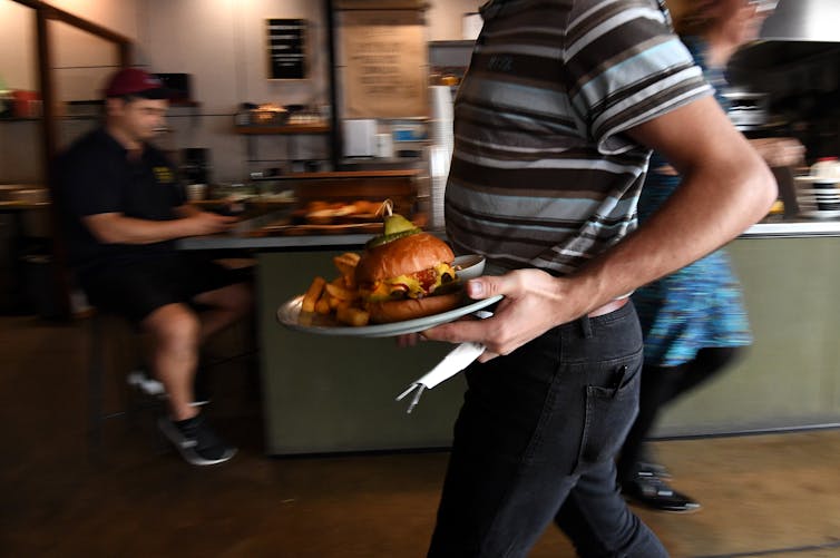 waiter carrying a plate of food in a restaurant