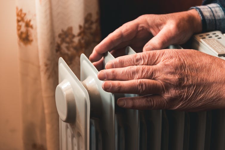 elderly person's hands on heater