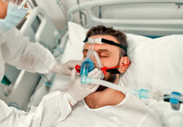 A COVID patient in hospital being given oxygen
