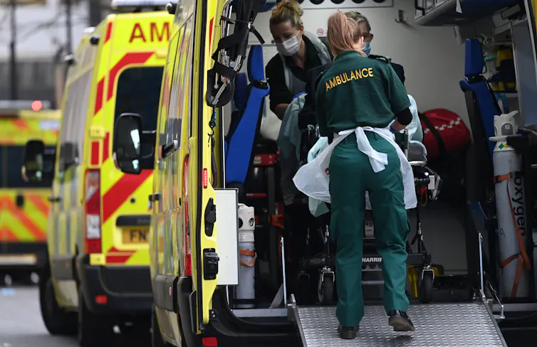 Paramedics transferring a patient from an ambulance into hospital