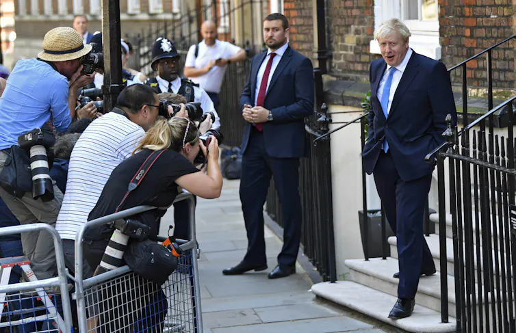Boris Johnson smiles for press cameras in the summer of 2019.