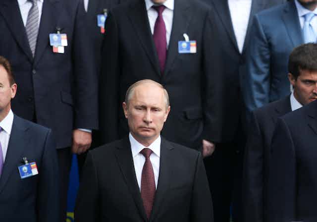 President Putin of Russia standing at a photocall.