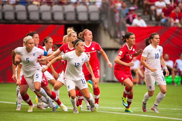 Canada and England players face the ball during a FIFA Women's World Cup Canada quarter-final in 2015.
