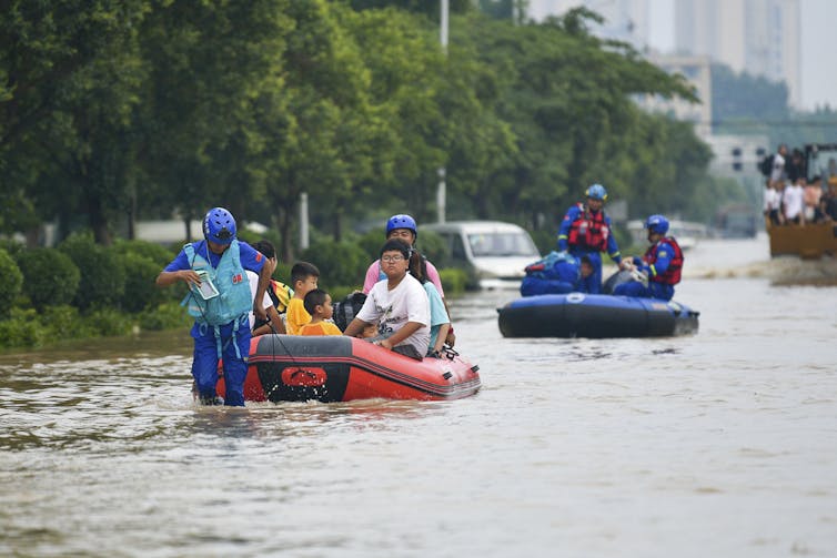 People on inflatable boats in a flooded street