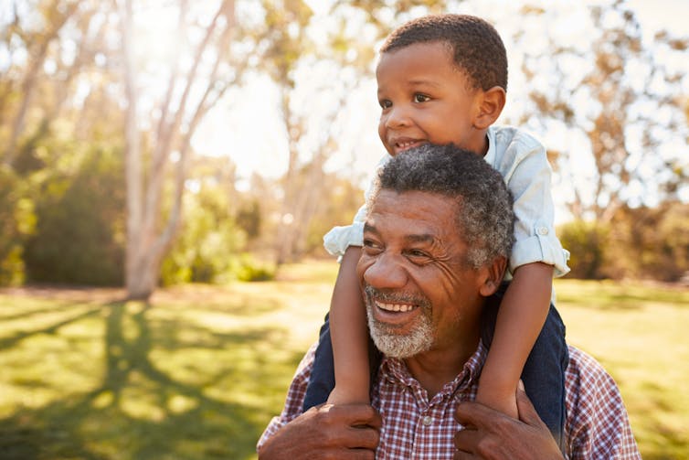 A grandfather and grandson walking outside