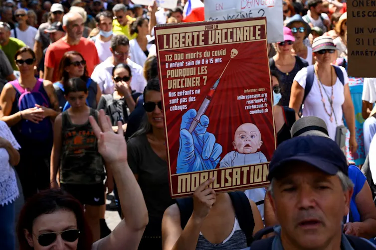 Dans une manifestation, une pancarte montrant le dessin d’un bébé horrifié avec des chiffres détournés sur le nombre de morts