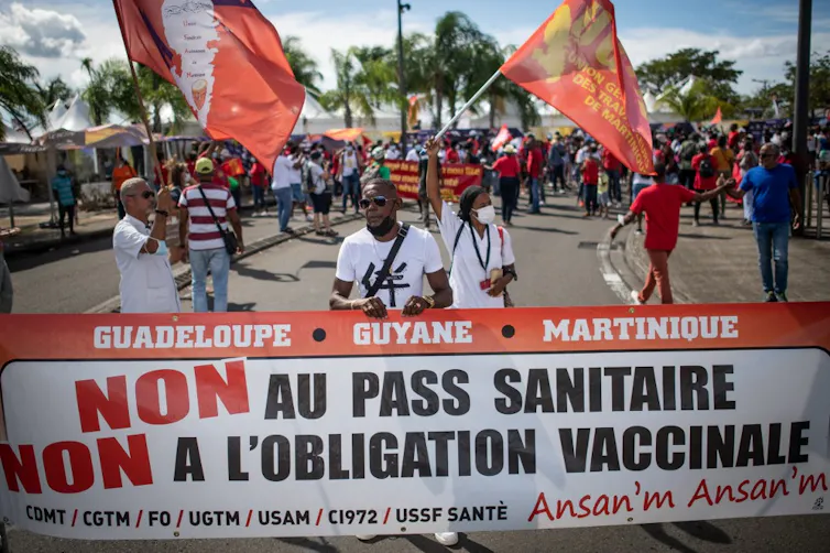 Manifestants brandissant des pancartes « Non au Pass Sanitaire, non à l’obligation vaccinale »