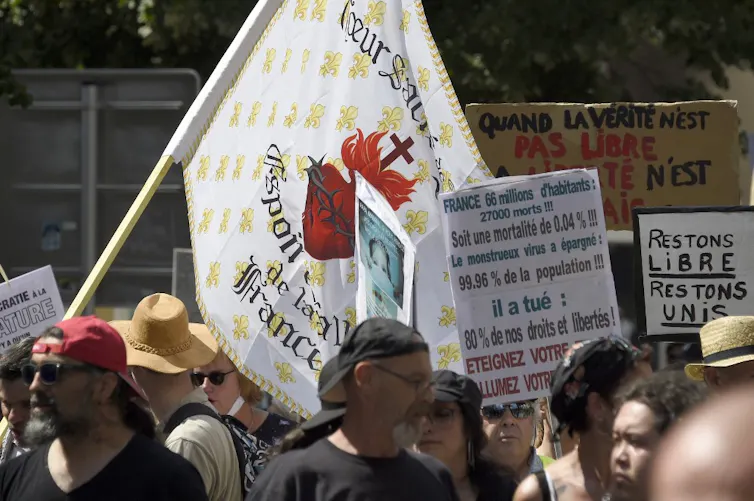 Manifestants brandissant des pancartes sur la « liberté », la « vérité », etc.