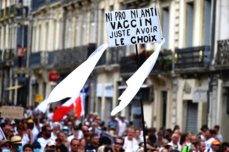 Manifestants avec une pancarte «Ni pro ni anti vaccin, juste avoir le choix»