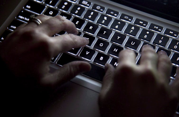Hands are seen typing on a keyboard.