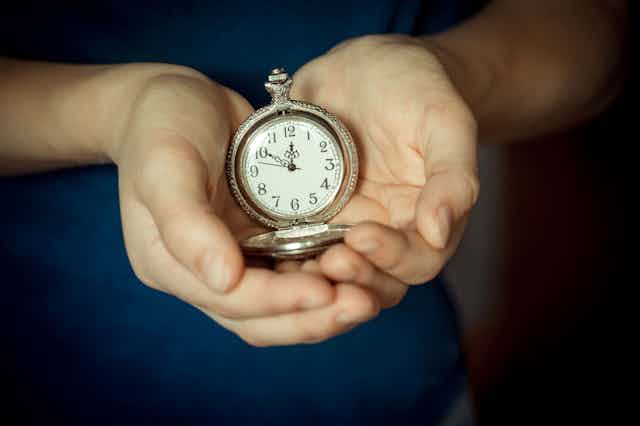 Hands holding pocket watch