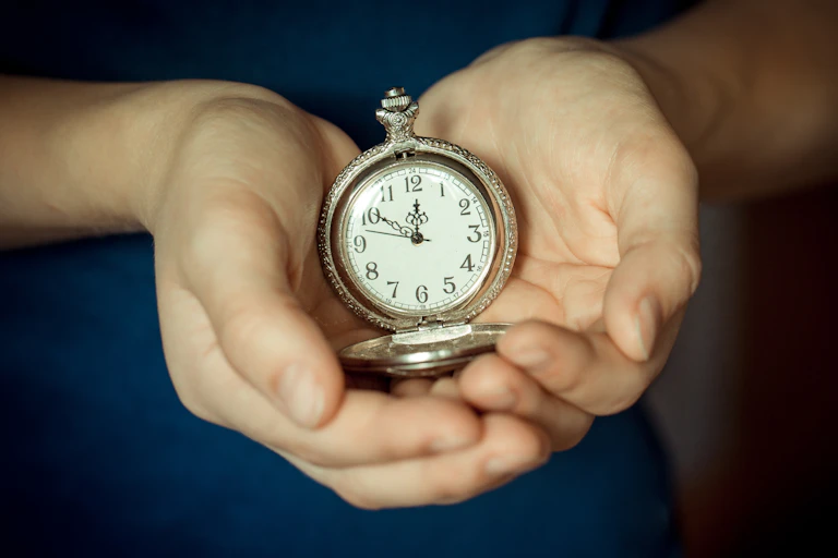 Hands holding pocket watch