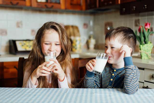 Two children drinking milk.