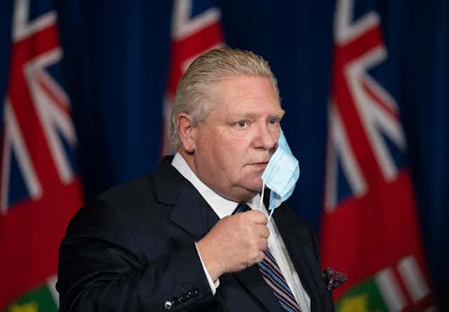 Doug Ford removes his mask at a press conference