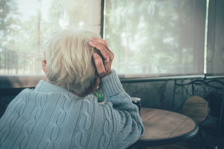 older woman sits alone