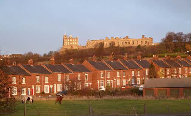 Houses in between a field and a castle