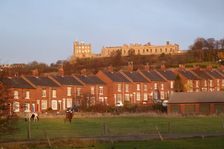 Houses in between a field and a castle