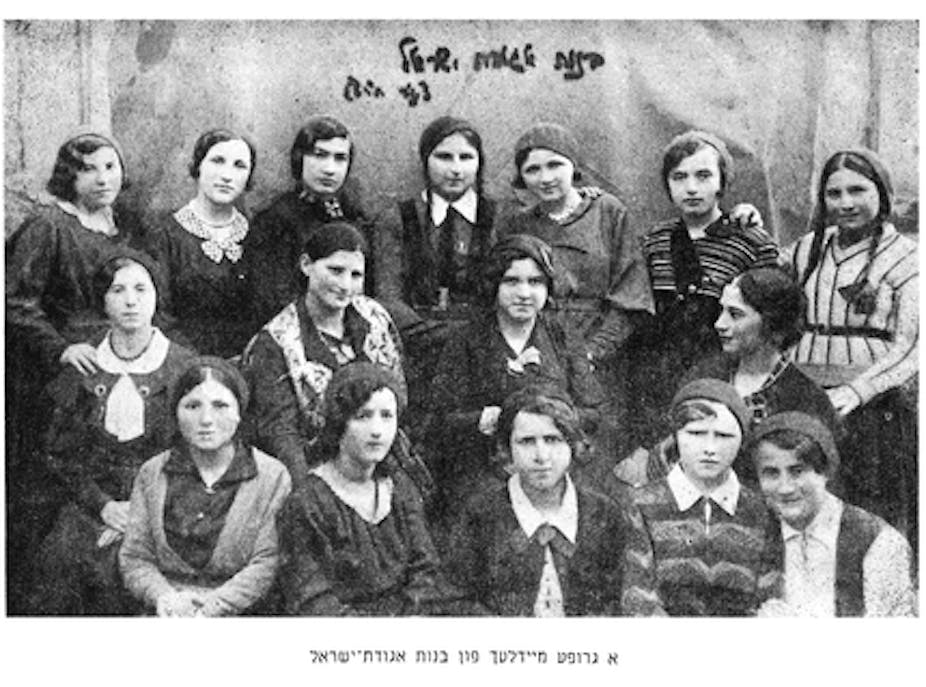 A black and white photograph shows teenage schoolgirls posing for a formal portrait.