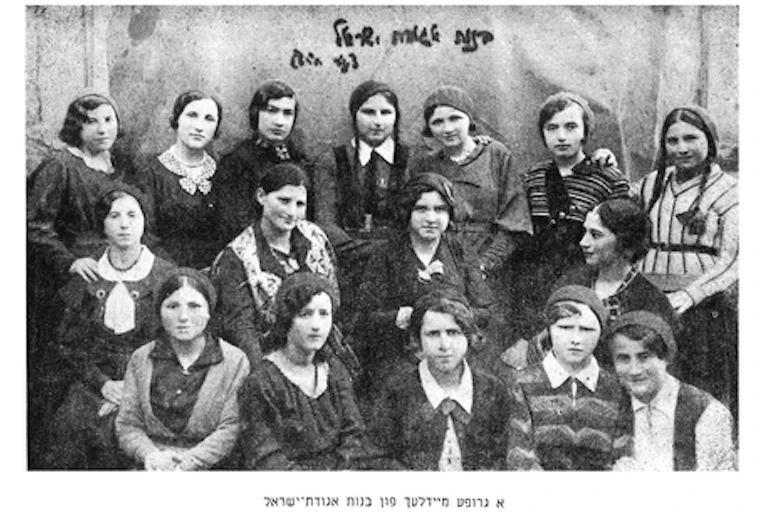 A black and white photograph shows teenage schoolgirls posing for a formal portrait.