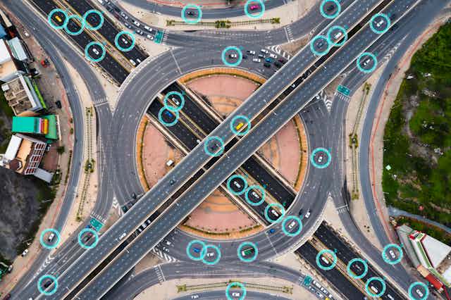 Graphic of highway interchange with many cars surrounded by small electric fields
