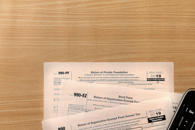 A pile of 990 forms on a desk