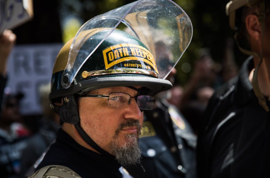 Stewart Rhodes in an eye patch and wearing a helmet with "Oath Keepers" written on it.