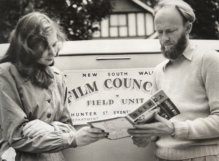 A man and a woman read a program