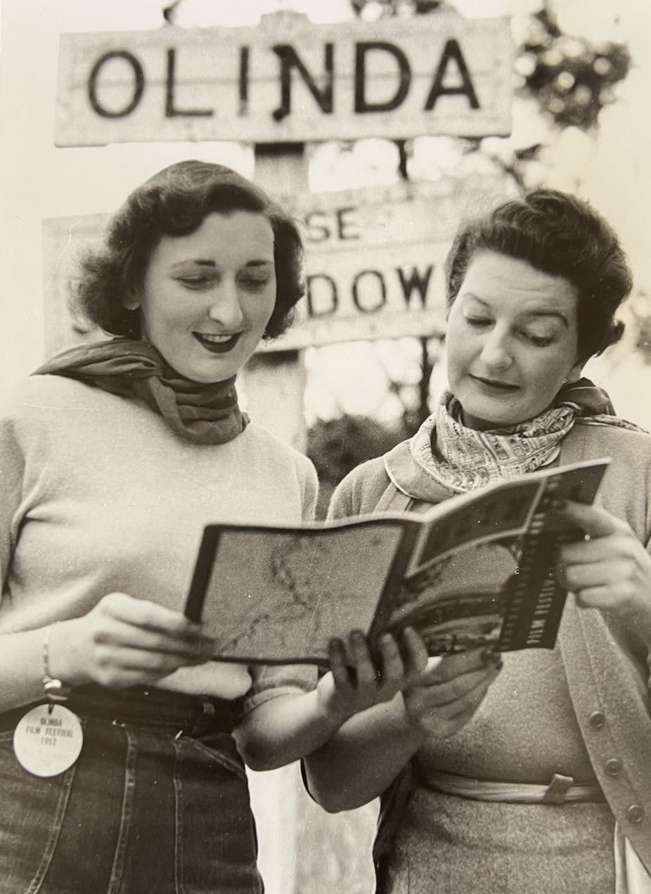 Two women reading the film program