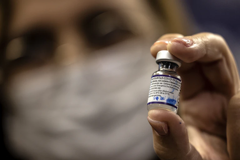Health worker holding a vial of the Pfizer COVID-19 vaccine