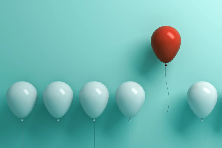 line of tethered balloons with one floating away