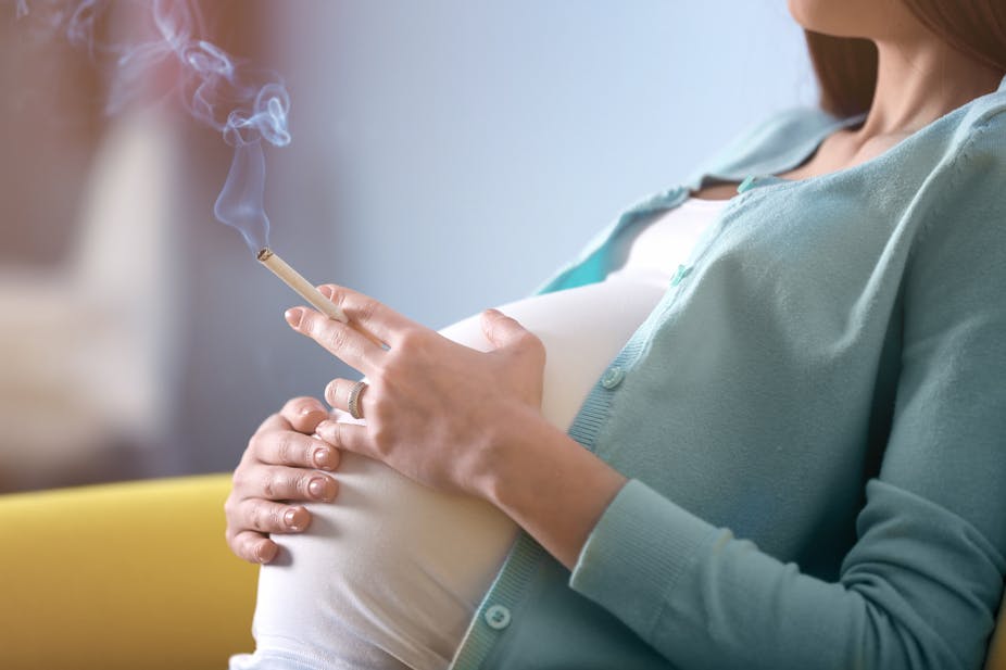 photo d’une femme enceinte avec une cigarette allumée à la main