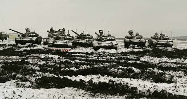 A row of tanks in a snowy field