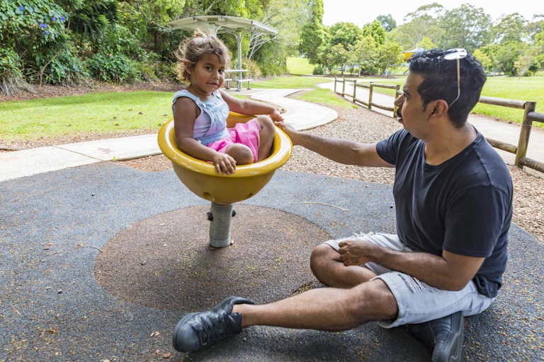 A man and his child at the playground.