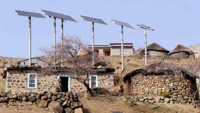 Solar panels on poles above a house