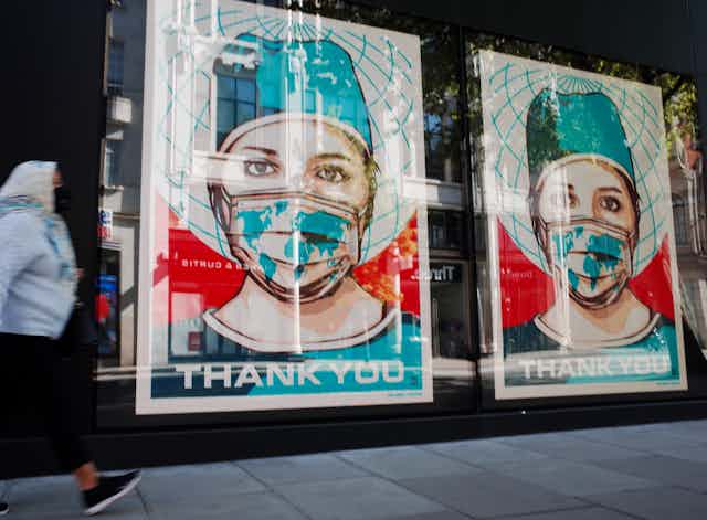 posters of masked health care workers in store window