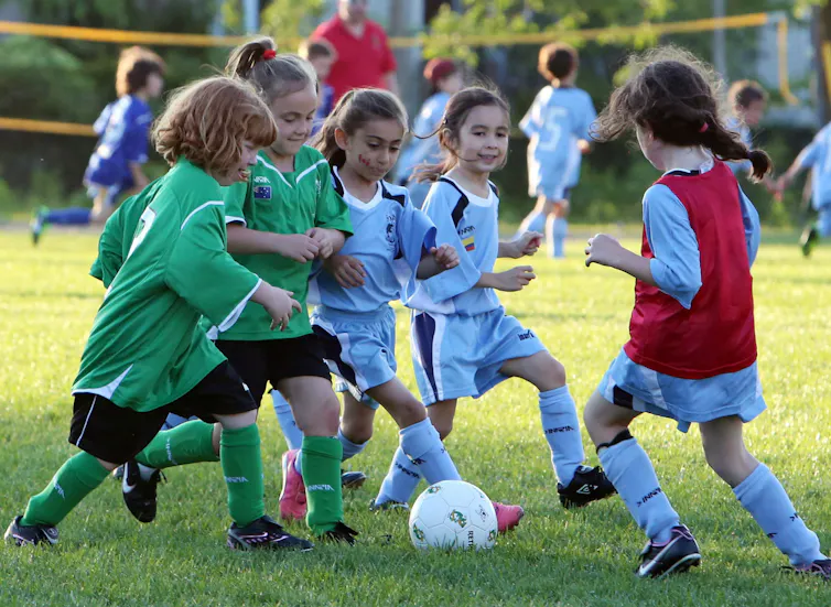Young girls play a soccer game outdoors.