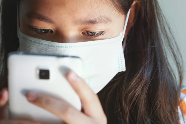 A girl stares at a mobile phone