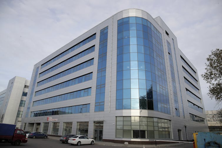 a seven-story office building with gray walls and blue windows