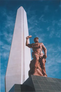 Statue shows a man carrying a touch in his right hand
