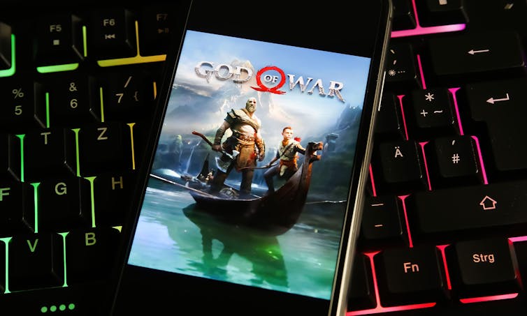 God of War game in front of PC keyboard