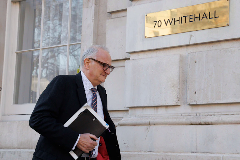 Lord Agnew walks by a Whitehall building while holding a folder under his arm