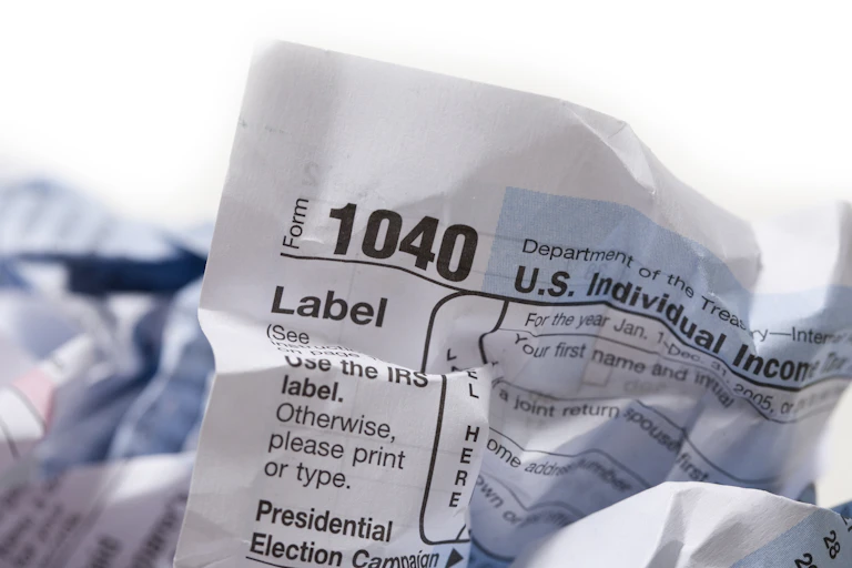 A crumbled-up 1040 form with some paper in the background