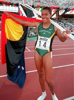 Cathy Freeman carrying the Aboriginal flag.