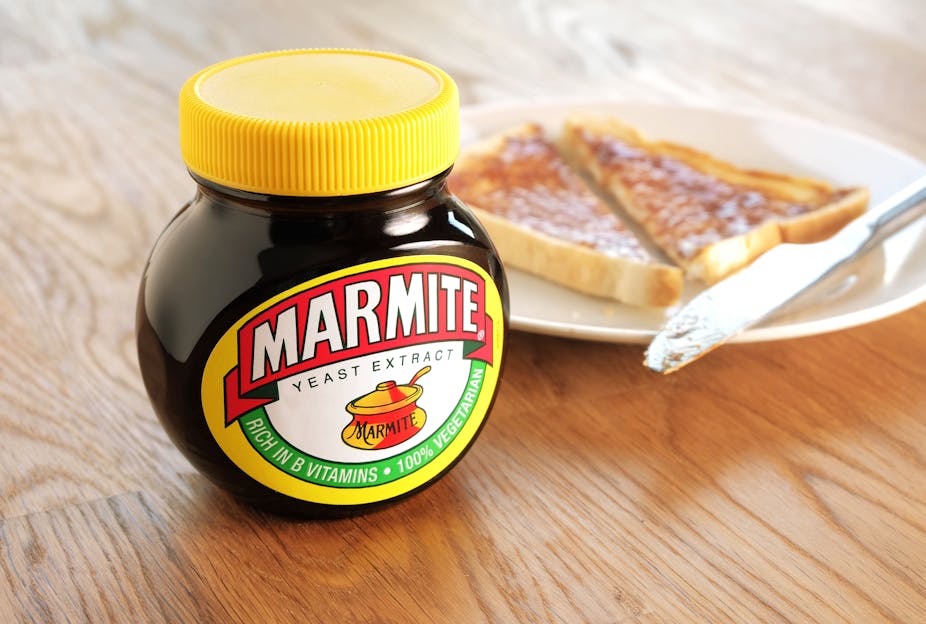 Jar of Marmite next to plate of toast.